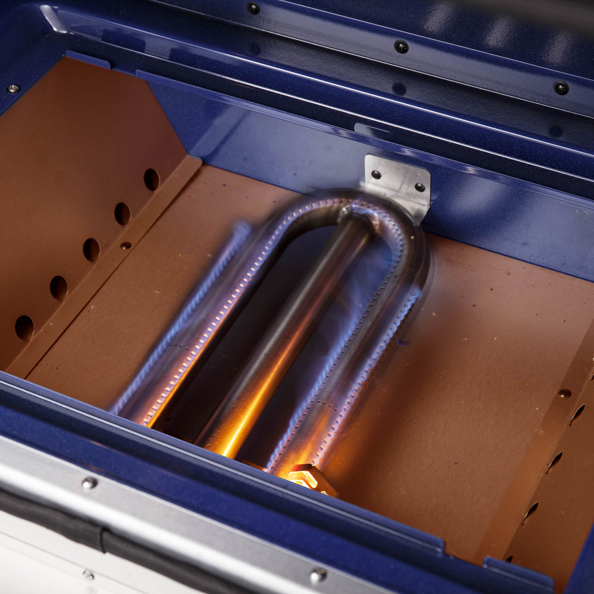 Gas oven interior with blue back panel and glowing broil/bake elements