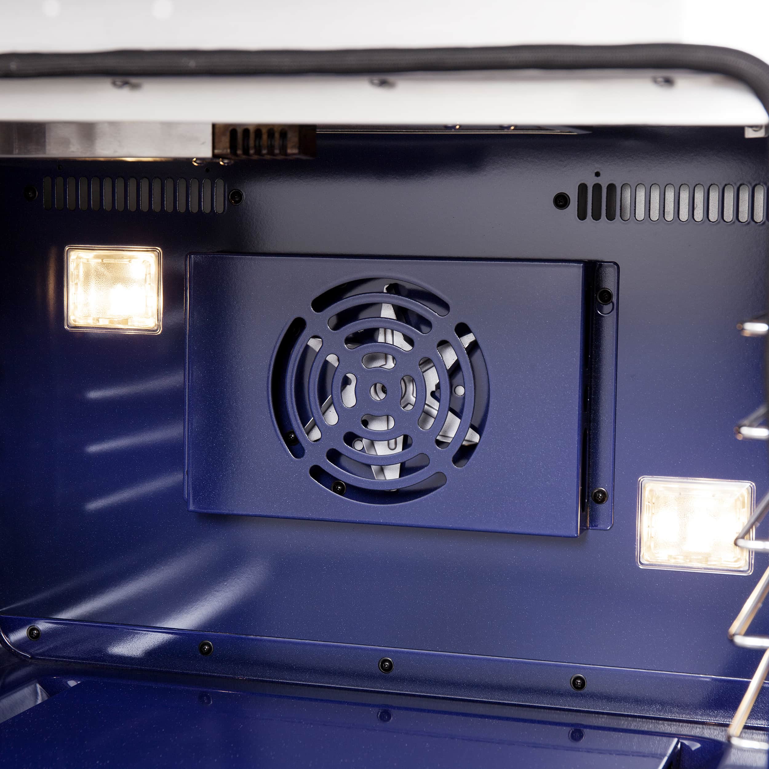 Gas oven cavity with circular fan vent and oven light