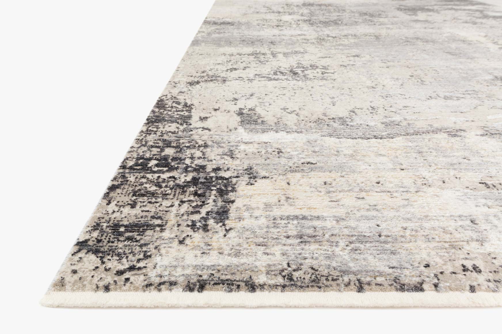 Area rug corner with distressed abstract design in light gray and dark charcoal flecks
