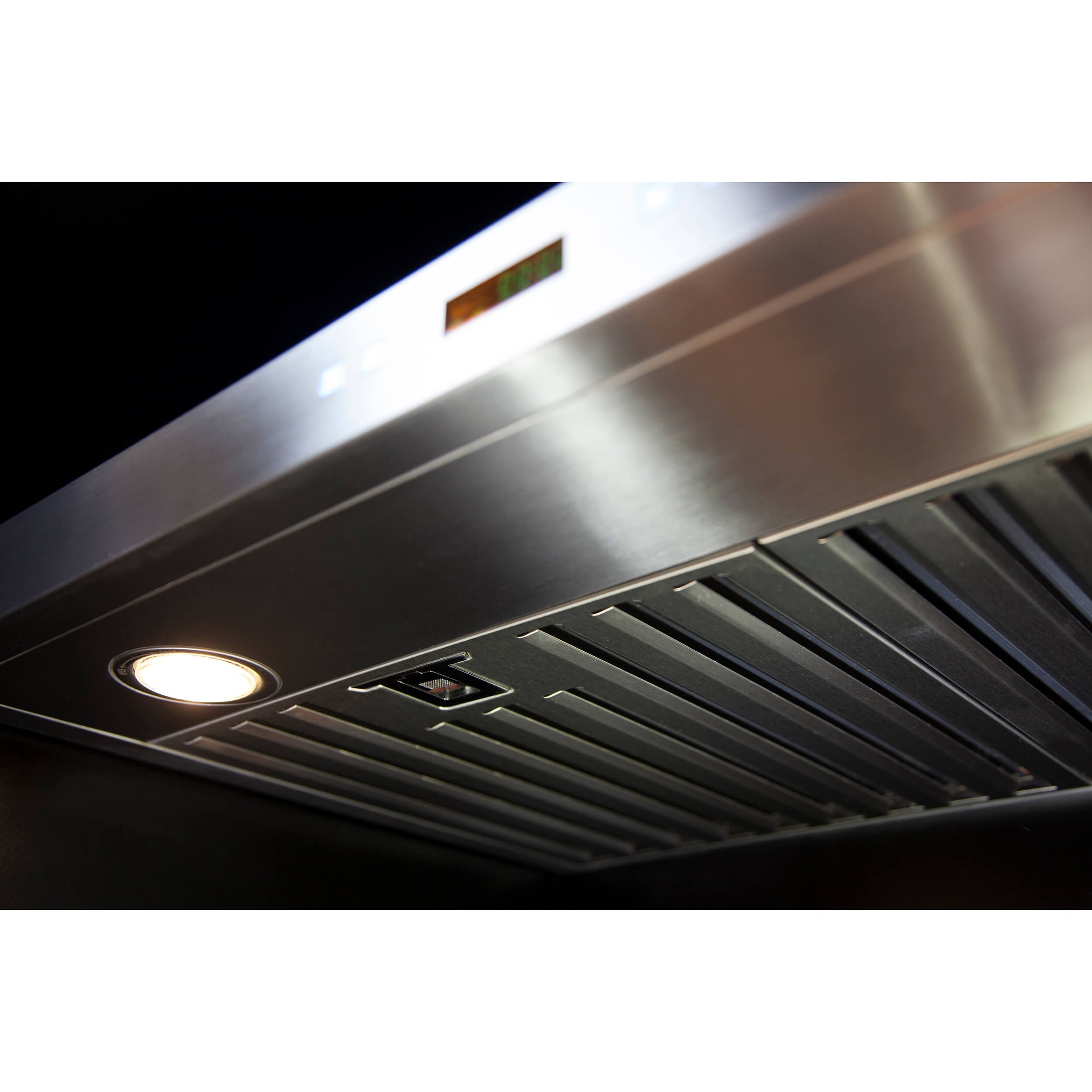 Stainless steel range hood underside with vent grilles and round light near controls