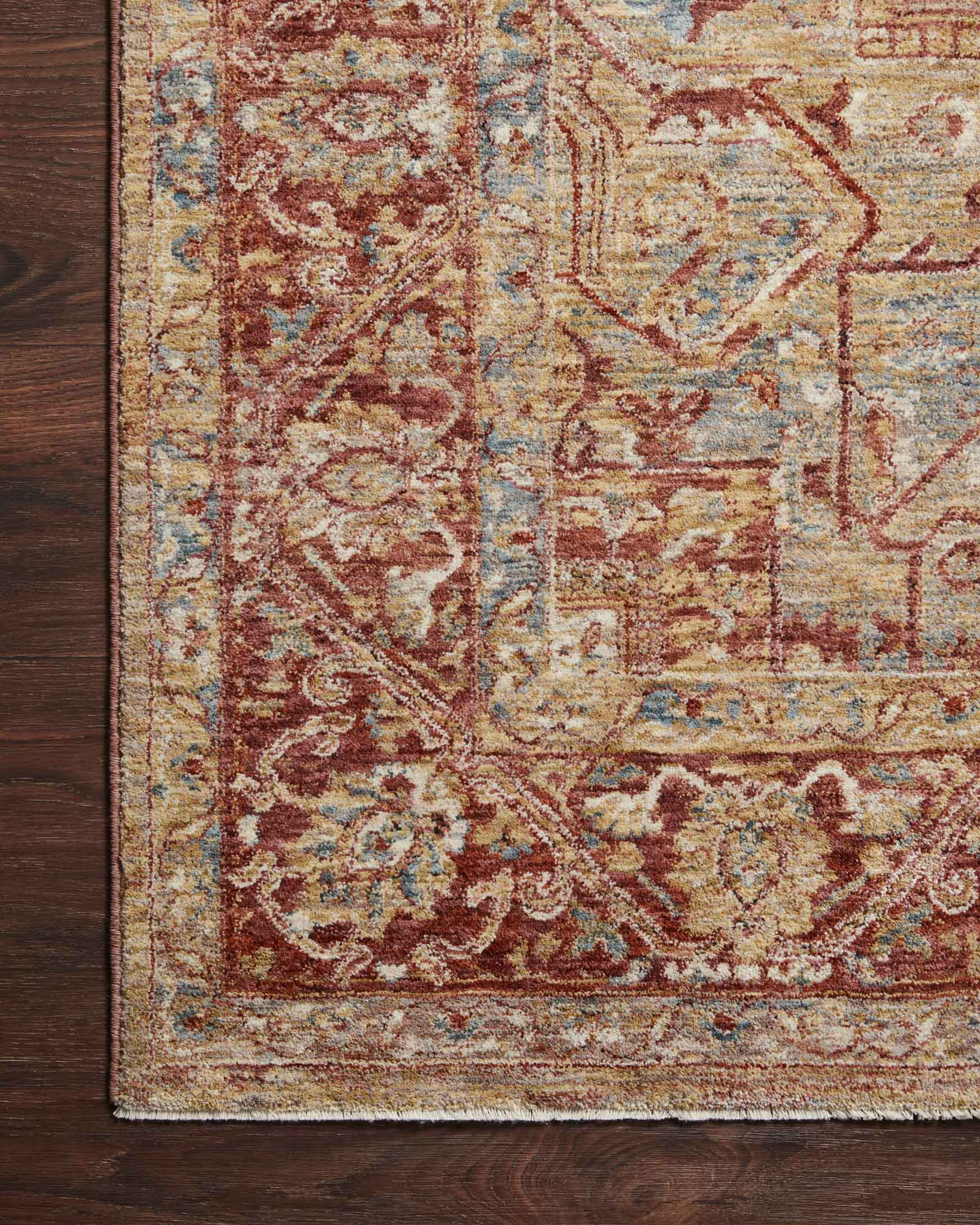 Transitional power-loomed rug edge detail with gold, brick and muted blue pattern