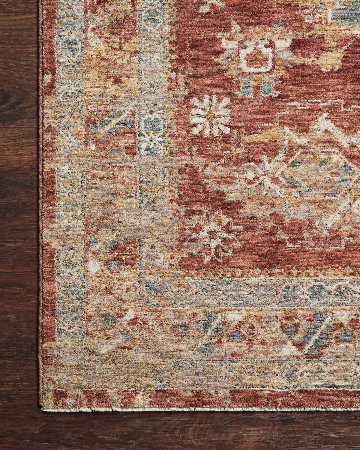 Gold, blue, and brick rug edge with distressed pattern detail and low-pile texture
