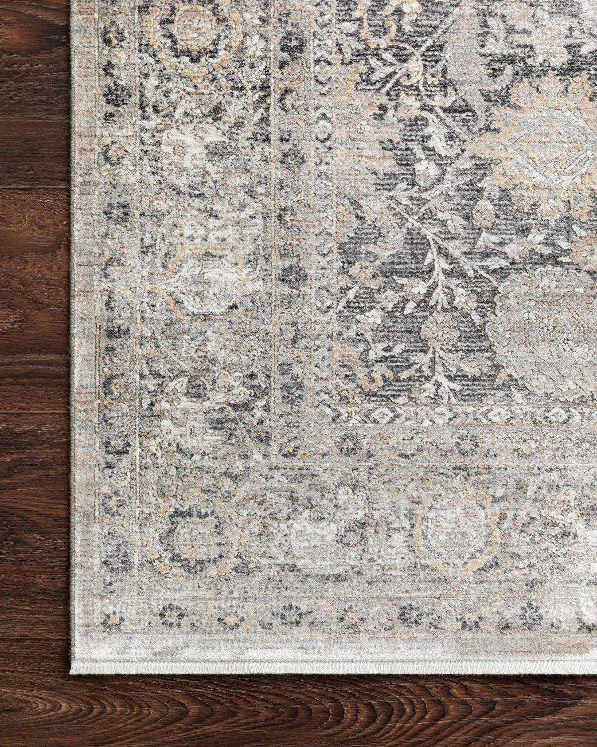 Charcoal and sand rug corner with distressed pattern and detailed border
