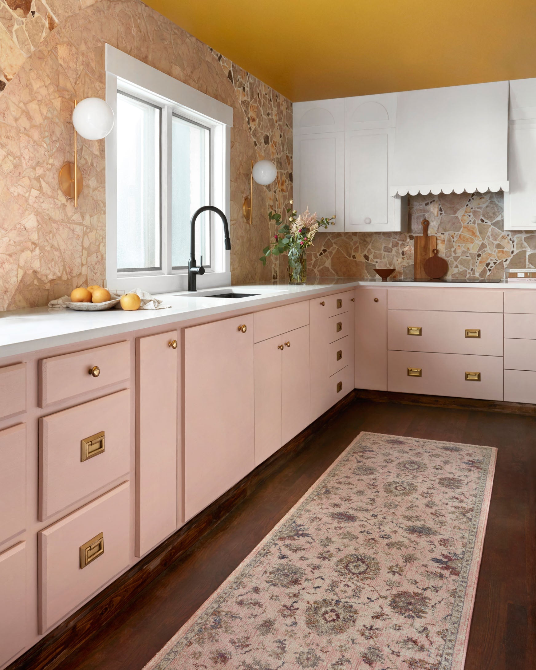 Blush floral traditional rug on hardwood floor with ornate border and center motifs