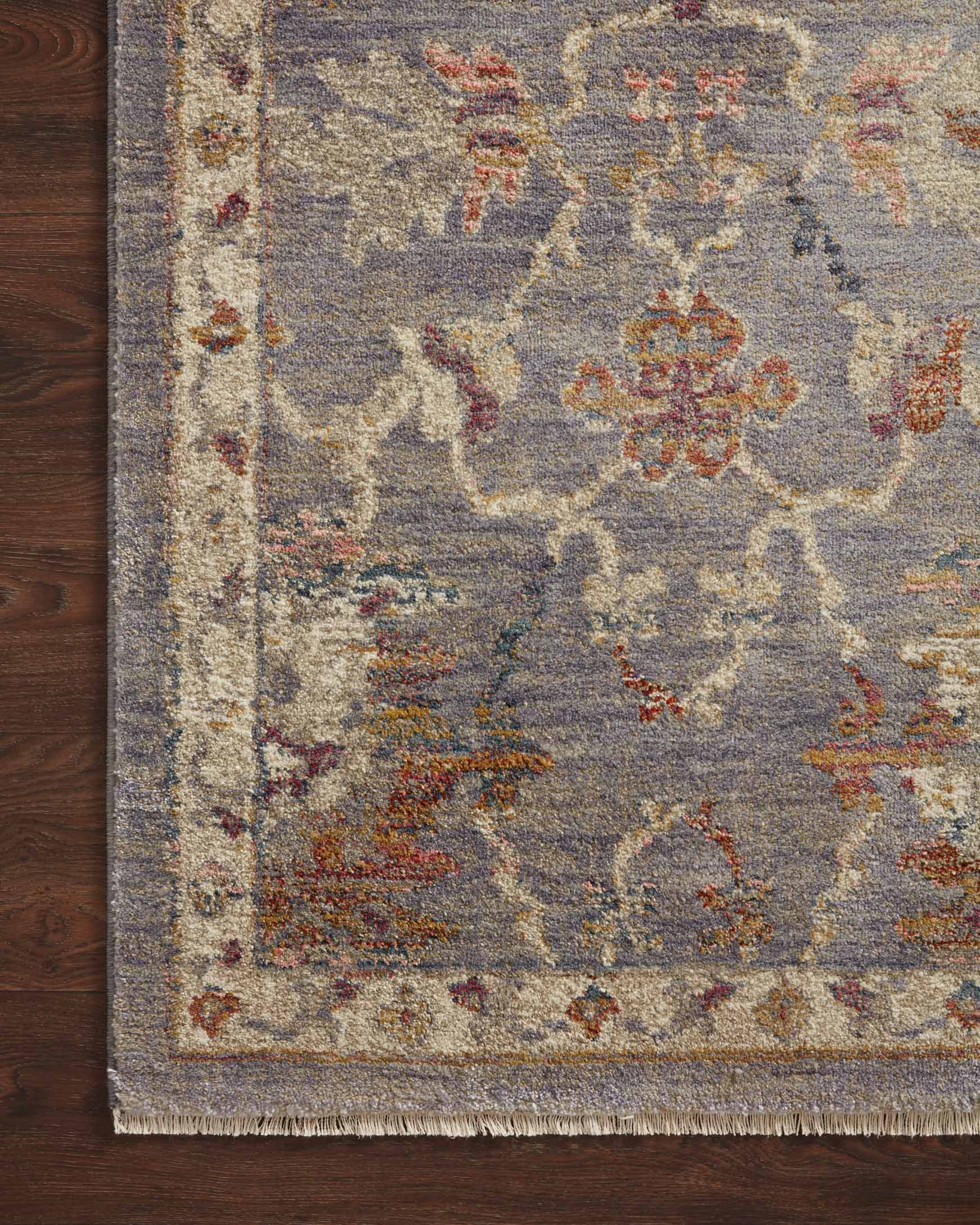 Rug corner detail in silver-gray with multicolor distressed floral pattern and textured weave