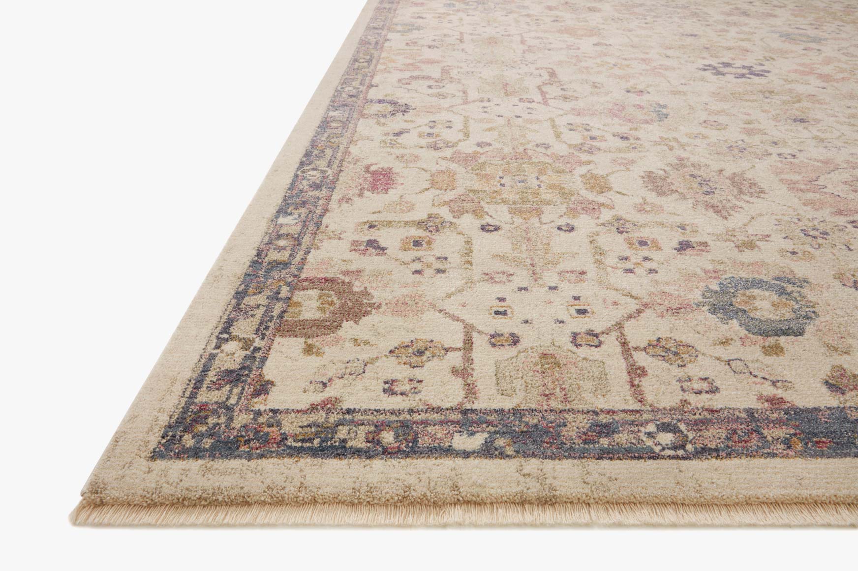 Corner view of ivory traditional rug with detailed motifs and dark blue border