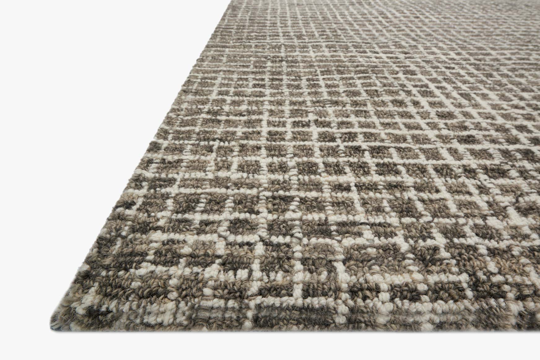 Corner close-up of charcoal hooked rug with faded grid design and loop texture