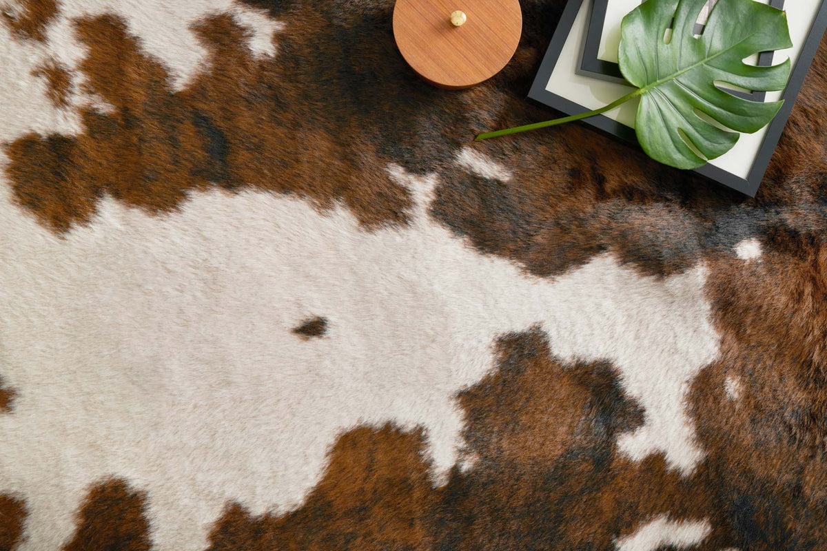 Close-up of beige and brown cowhide-style rug with irregular blotch pattern