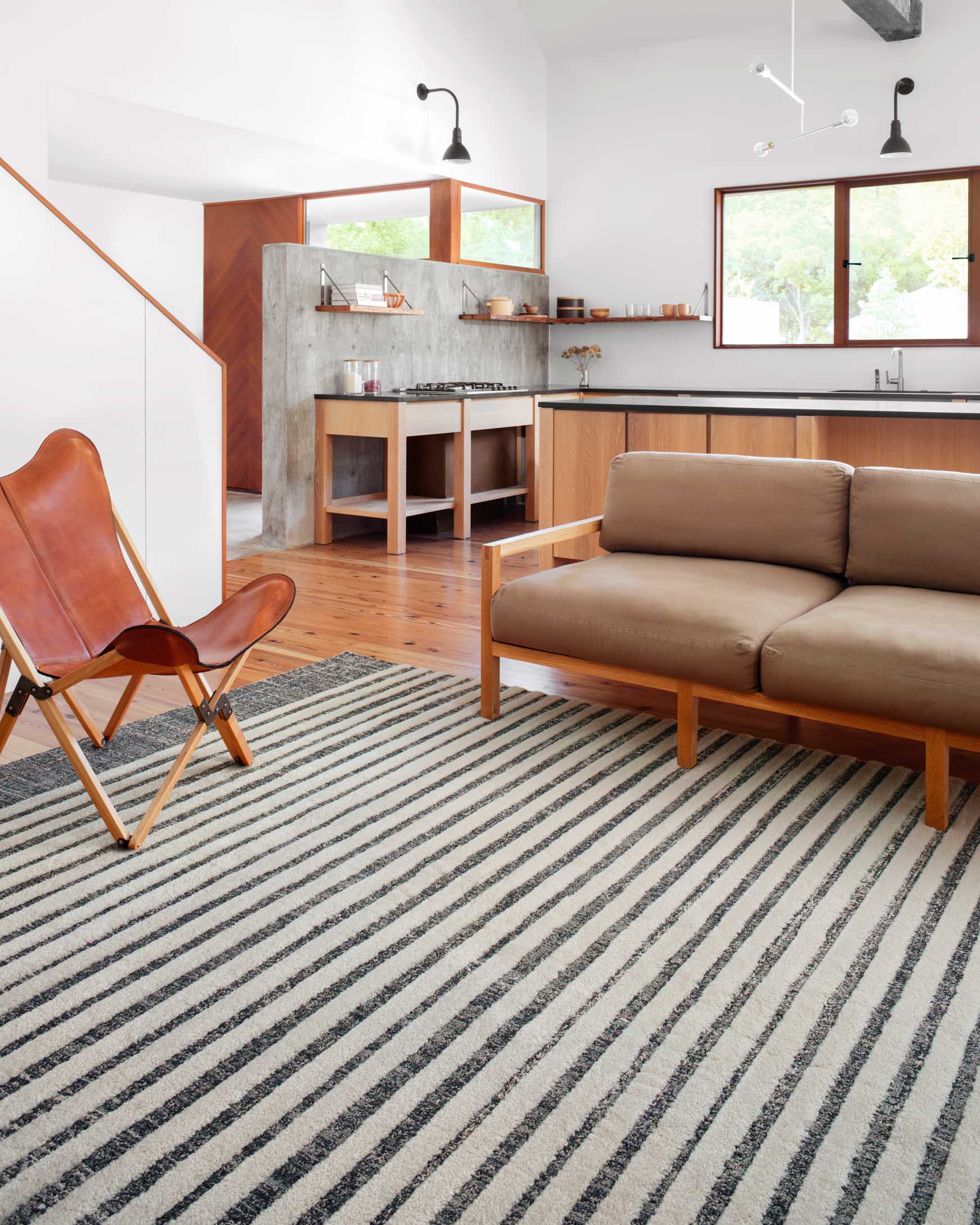 White and ocean blue striped power-loomed rug shown in a living room