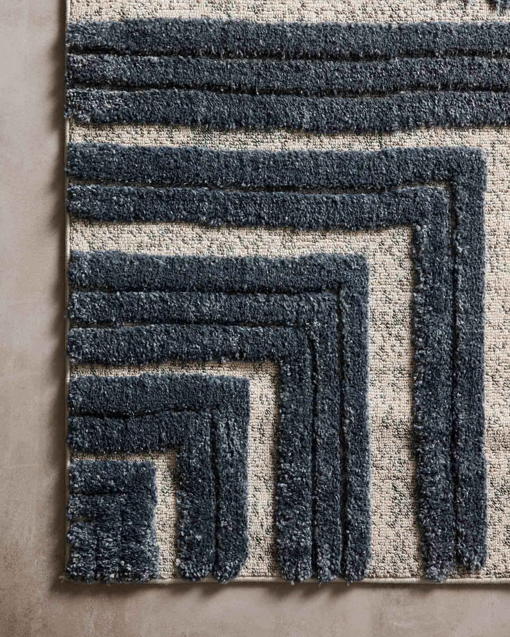 Blue and white power-loomed rug edge with stepped geometric border detail