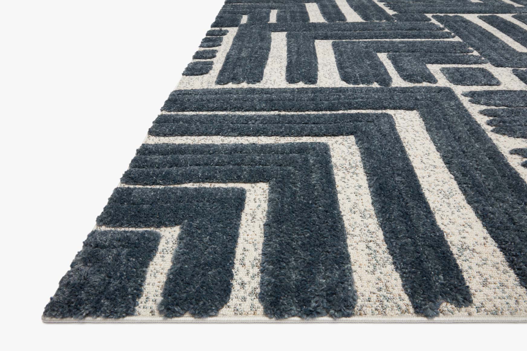 Blue and white geometric power-loomed rug with repeating outlined shapes, angled