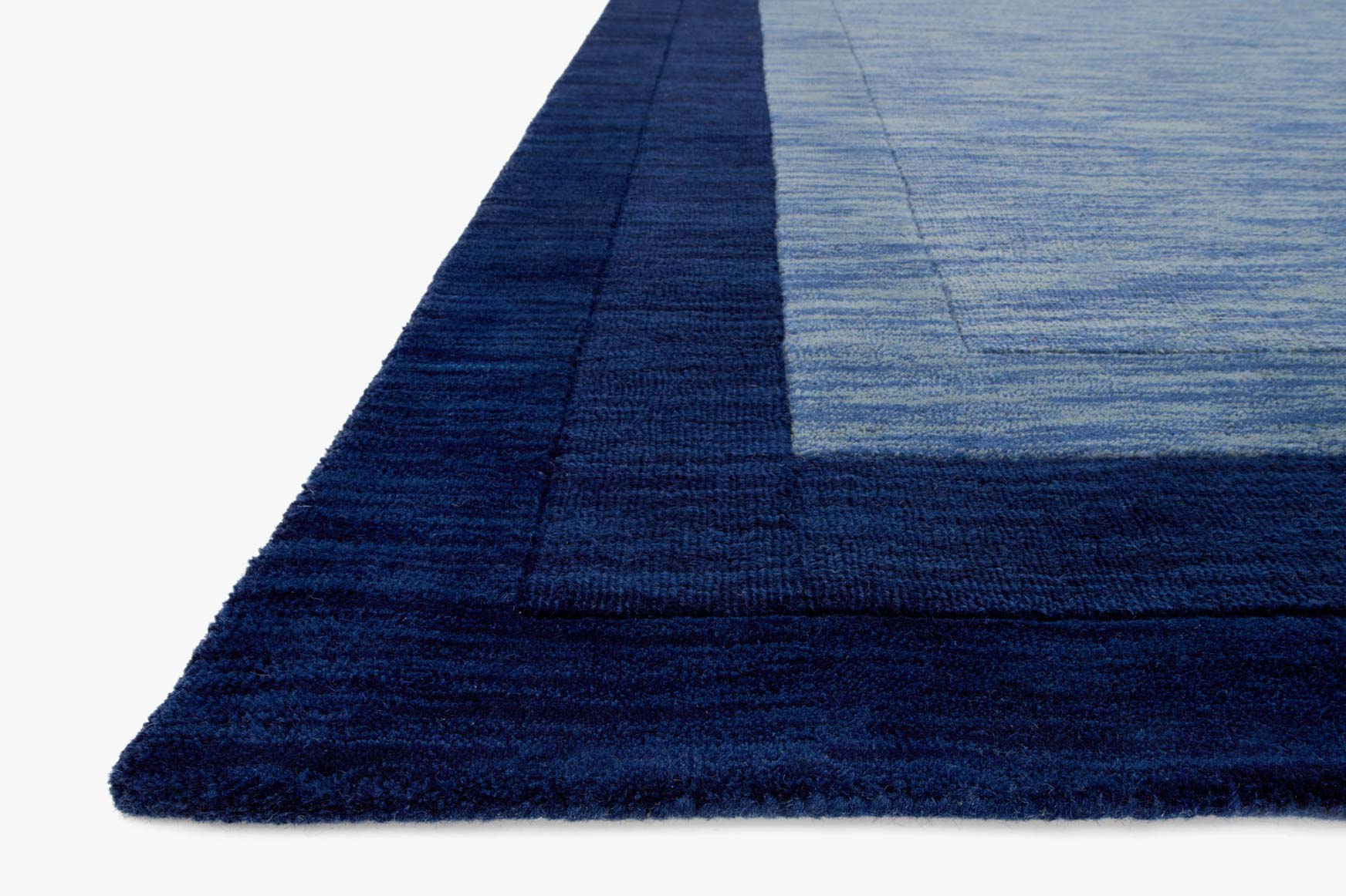 Navy corner of transitional hand-loomed rug with layered border and textured pile