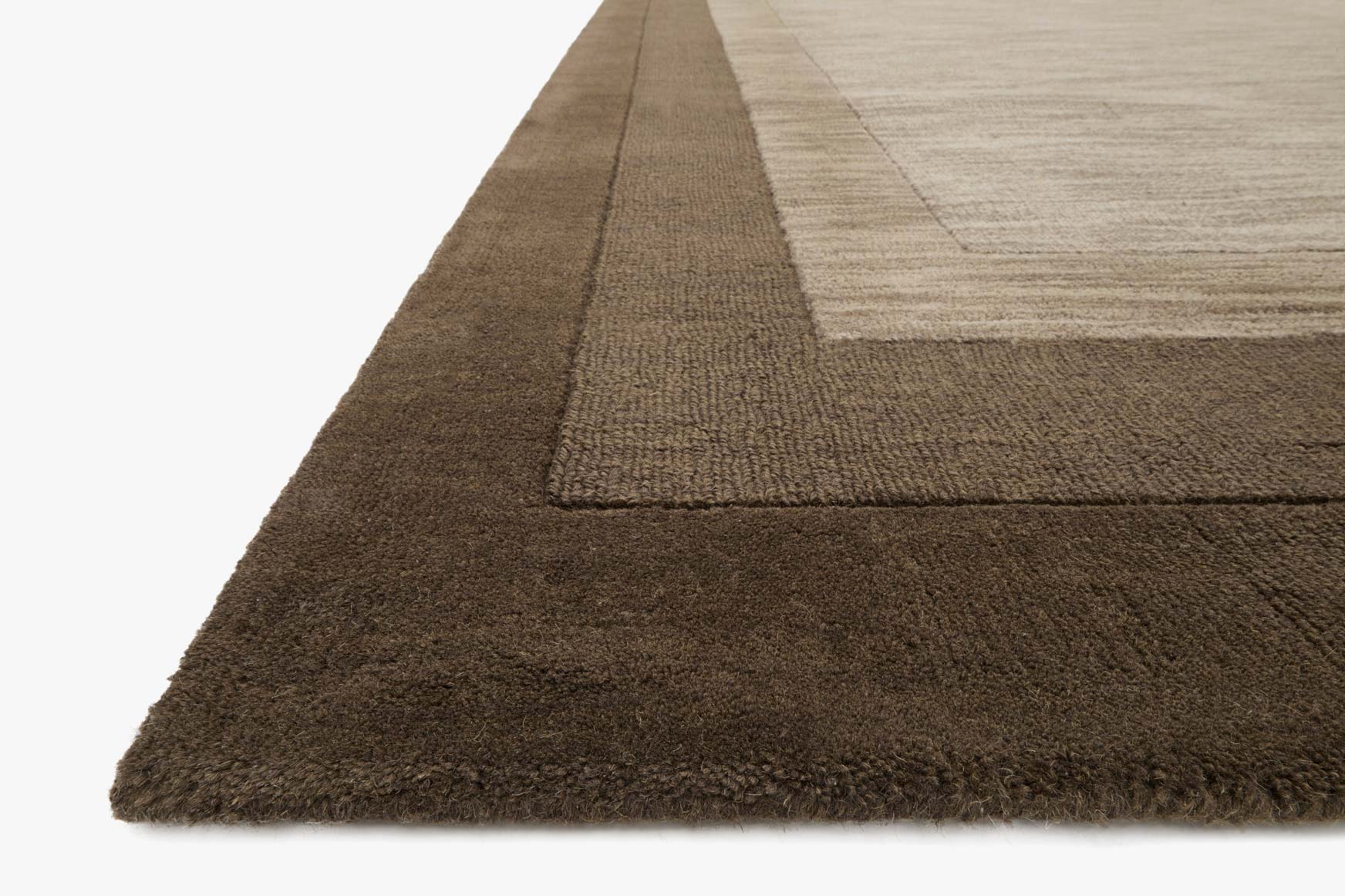 Corner detail of dark brown textured rug with light center, rectangular.