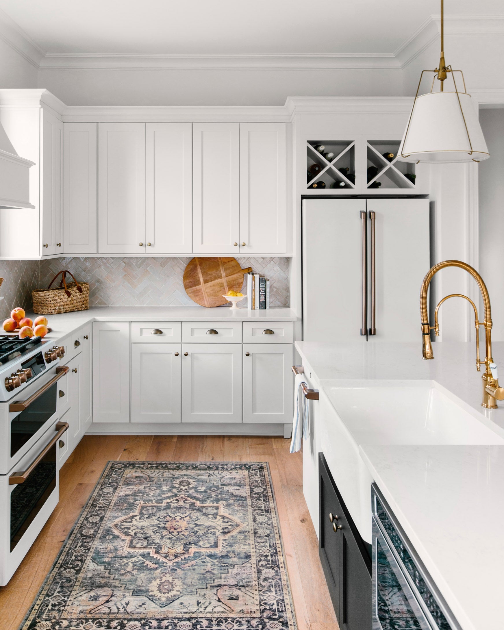 Traditional patterned navy rug in a bright kitchen with sink and cabinet backdrop