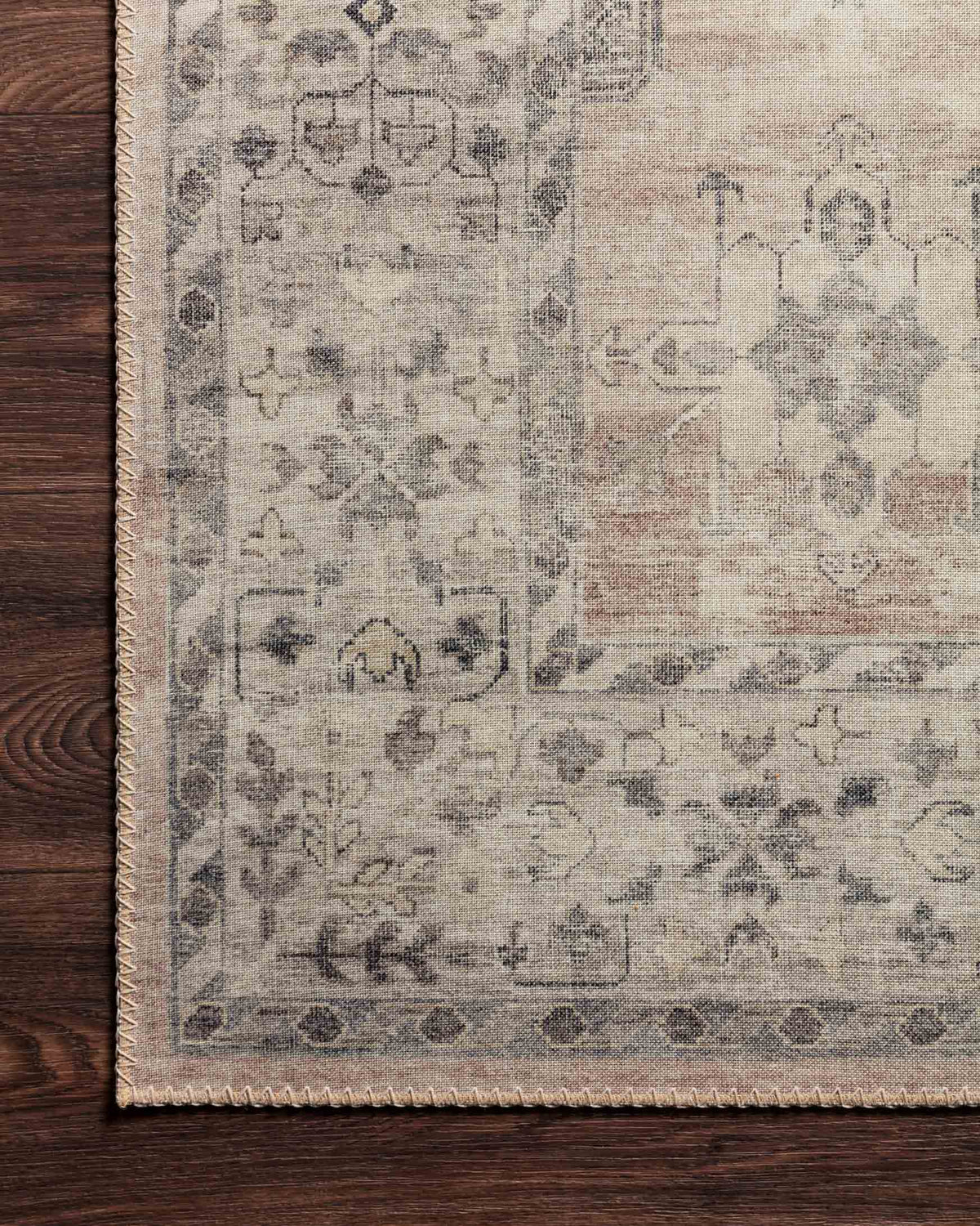 Traditional power-loomed rug corner detail with distressed geometric motifs and border.