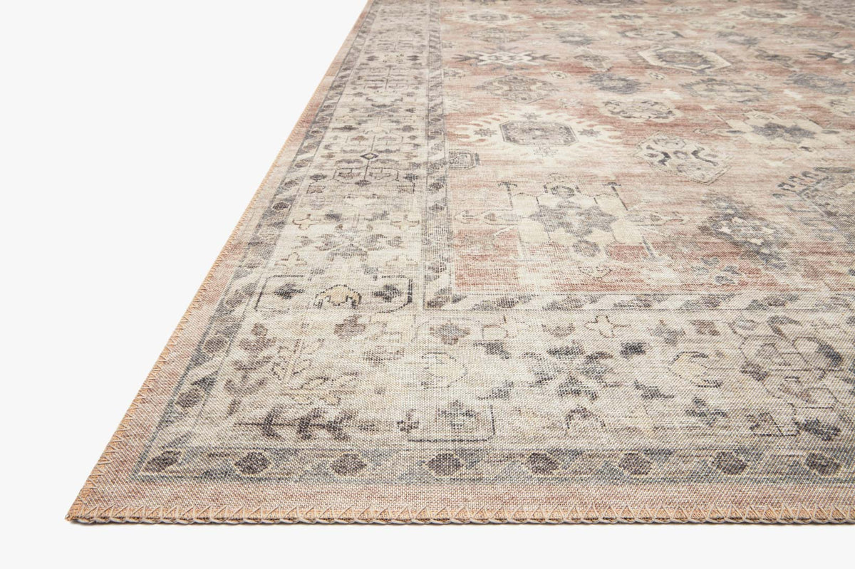 Traditional power-loomed rug corner diagonal view, distressed medallion pattern with tan fringe.