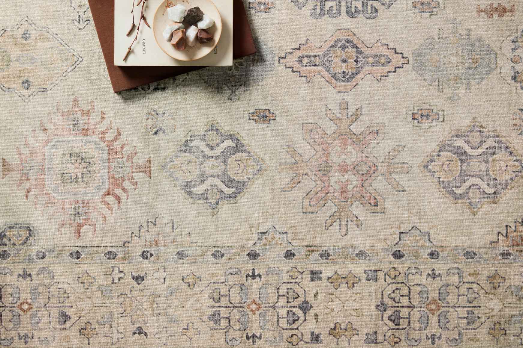 Beige traditional rug detail with blue and rust geometric pattern bands