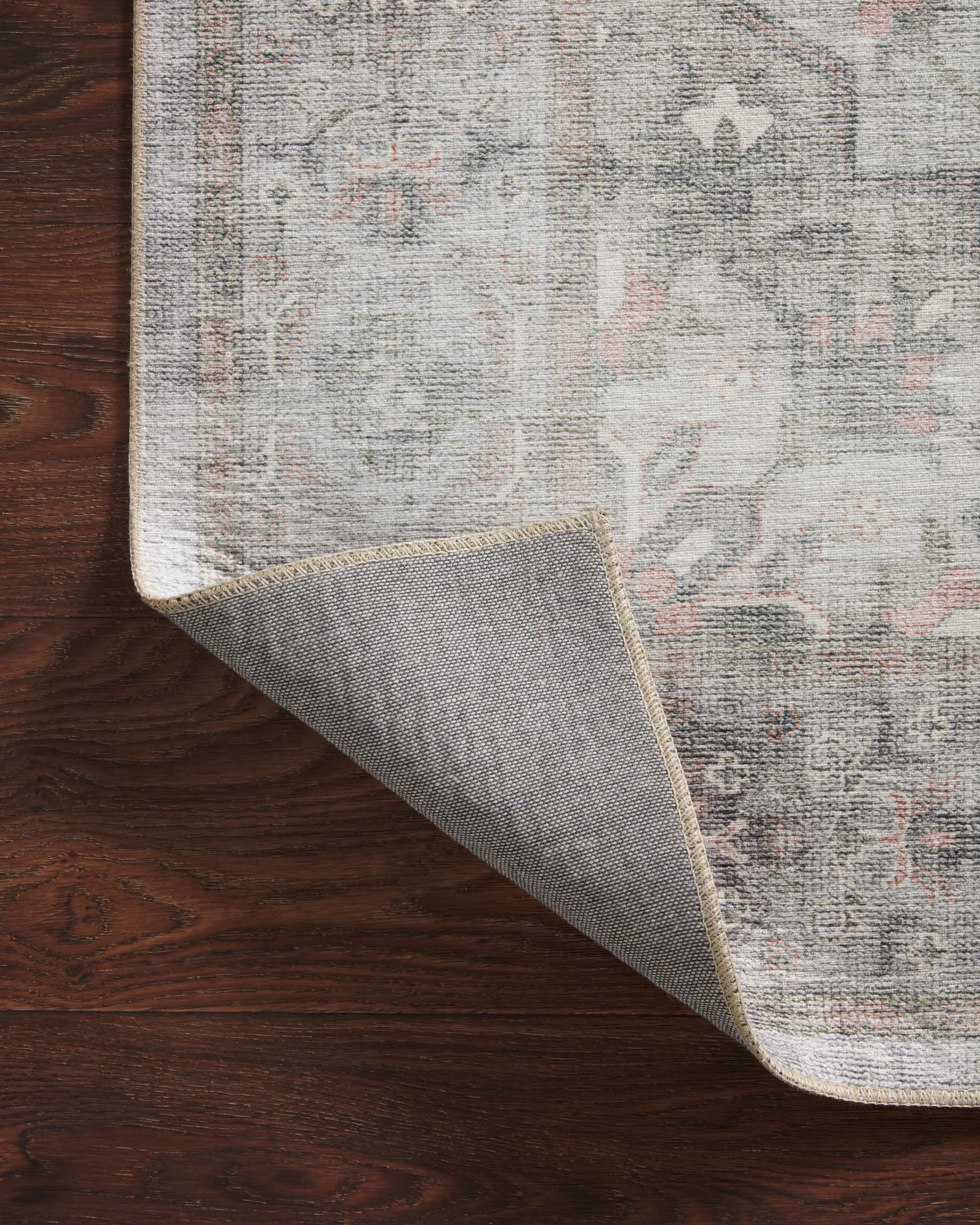 Traditional power-loomed rug folded edge with dove gray pattern and woven backing.