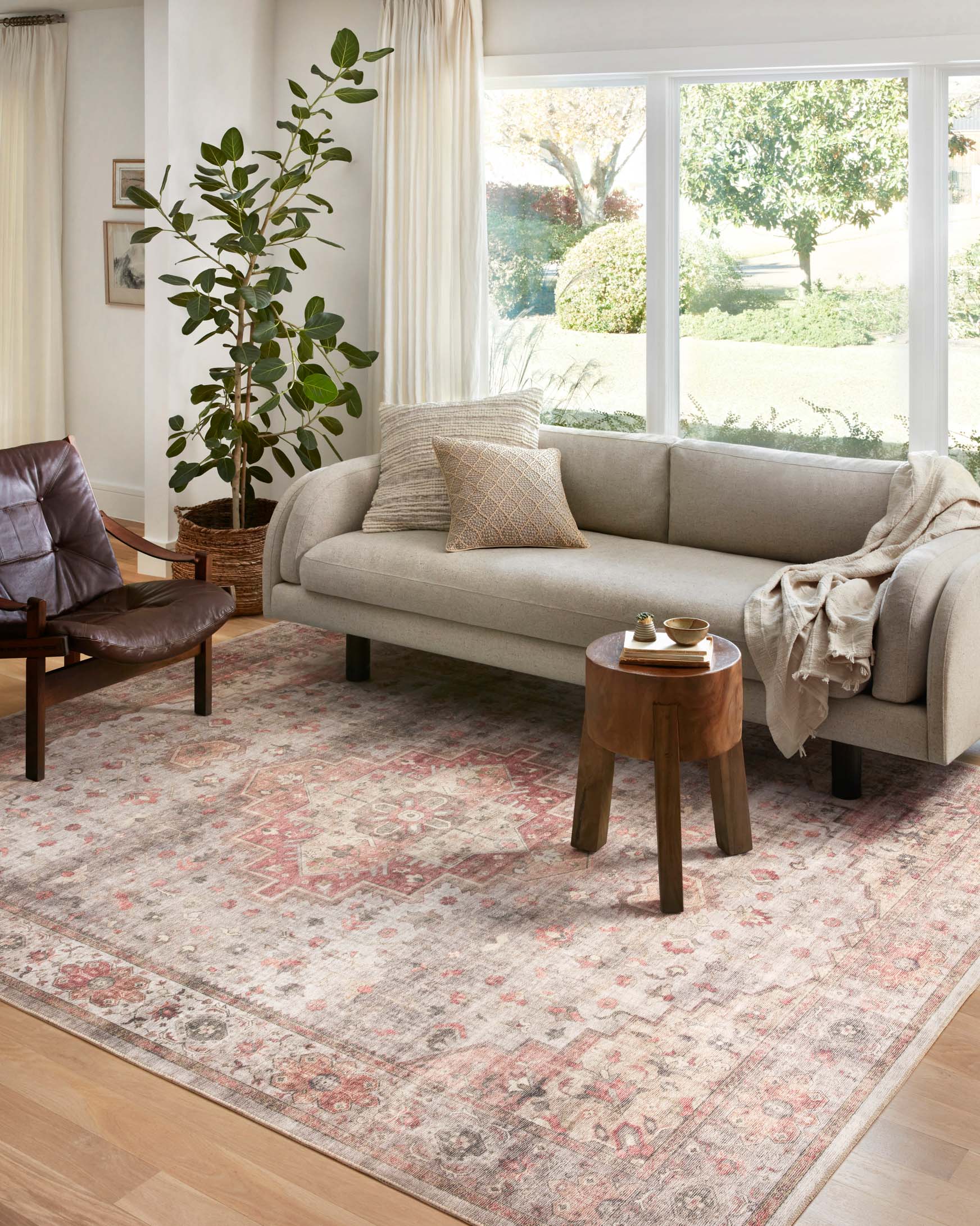 Traditional power-loomed rug, light gray with rust and coral motifs in a living room