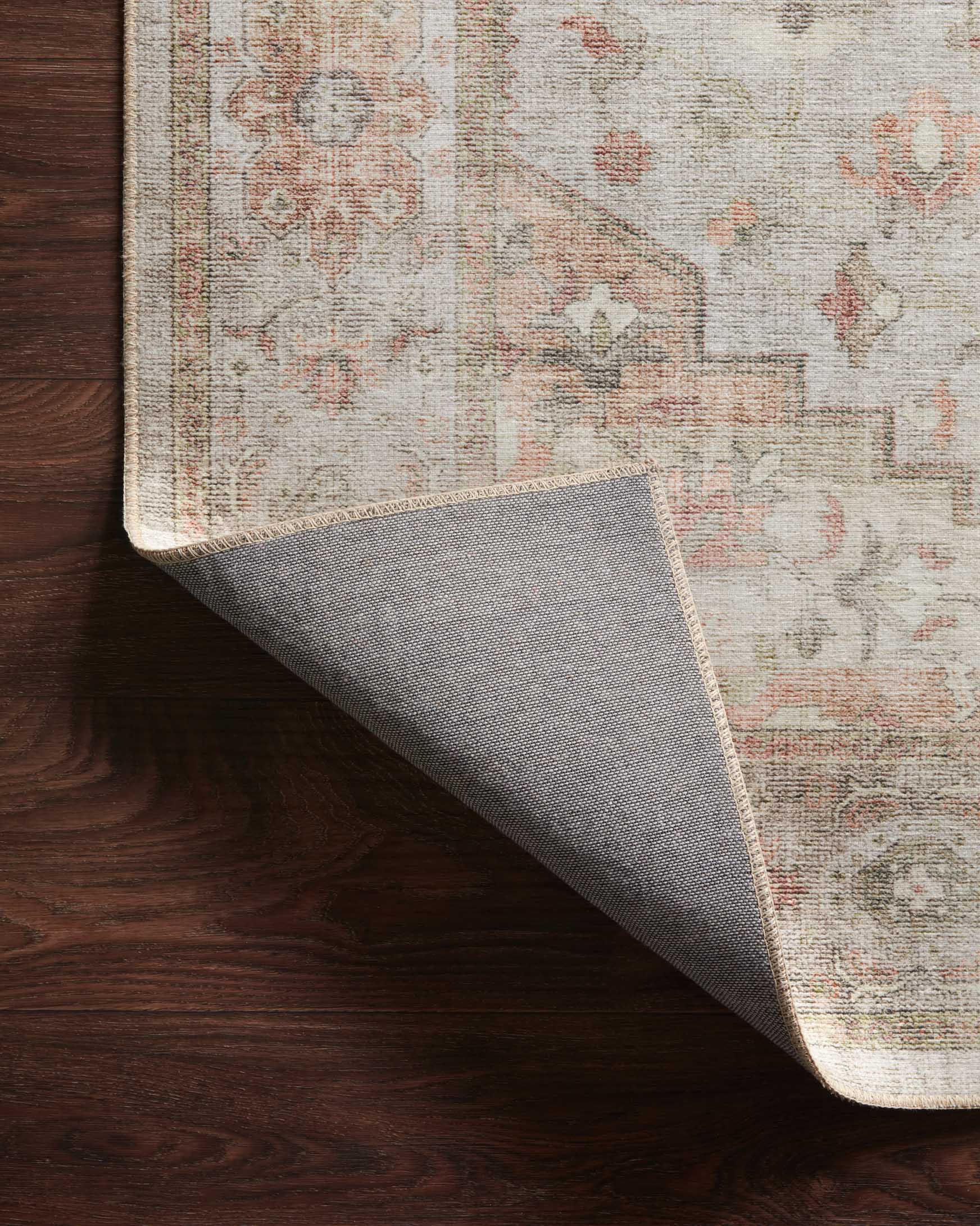 Traditional power-loomed rug corner with woven underside and muted geometric pattern in sage tones