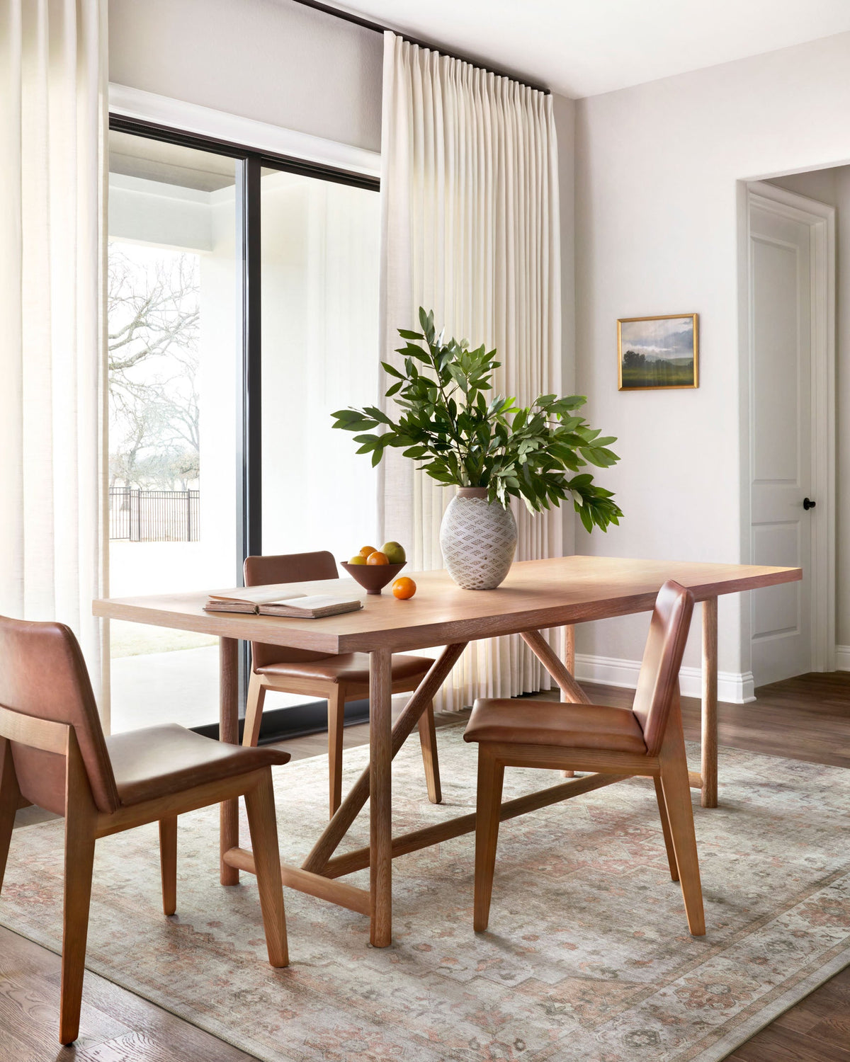 Traditional power-loomed rug laid under dining table, featuring faded geometric border in sage