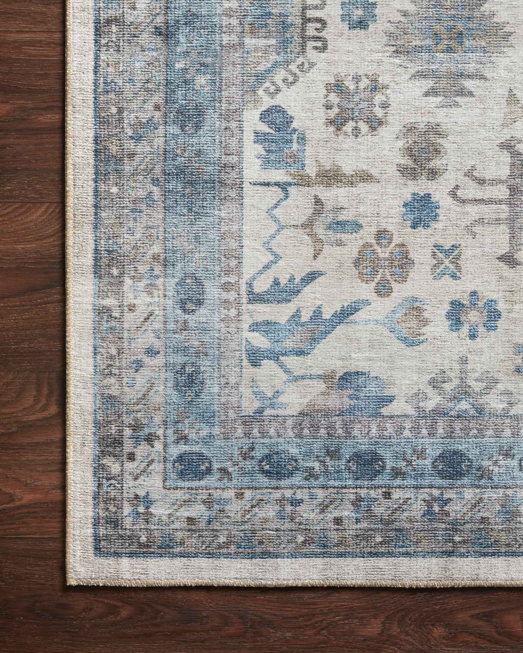 Corner of ivory and ocean blue rug showing patterned border and woven texture
