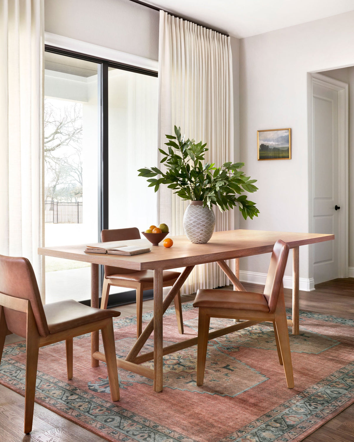 Rust red area rug with aqua motifs and border, centered in a dining room, rectangular