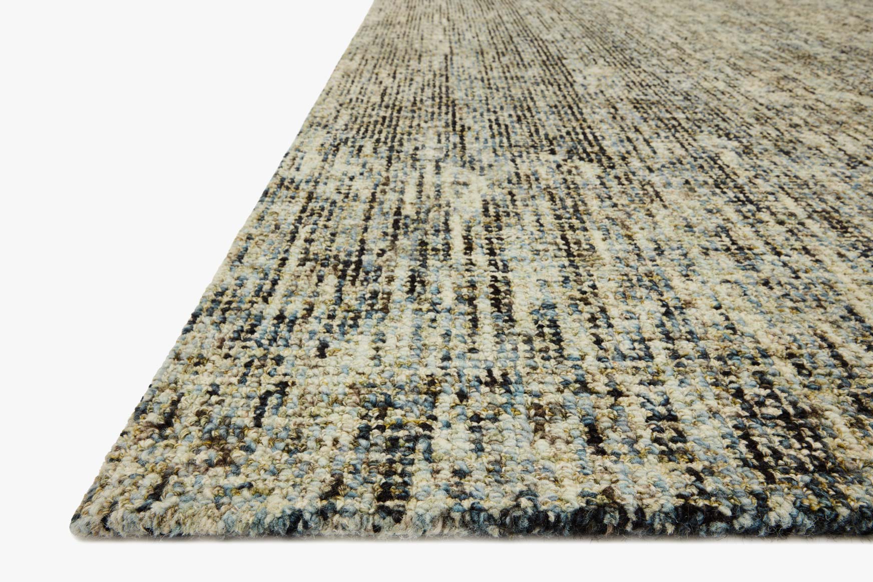 Hand-tufted rug corner detail with multitone olive, denim-blue, and cream texture