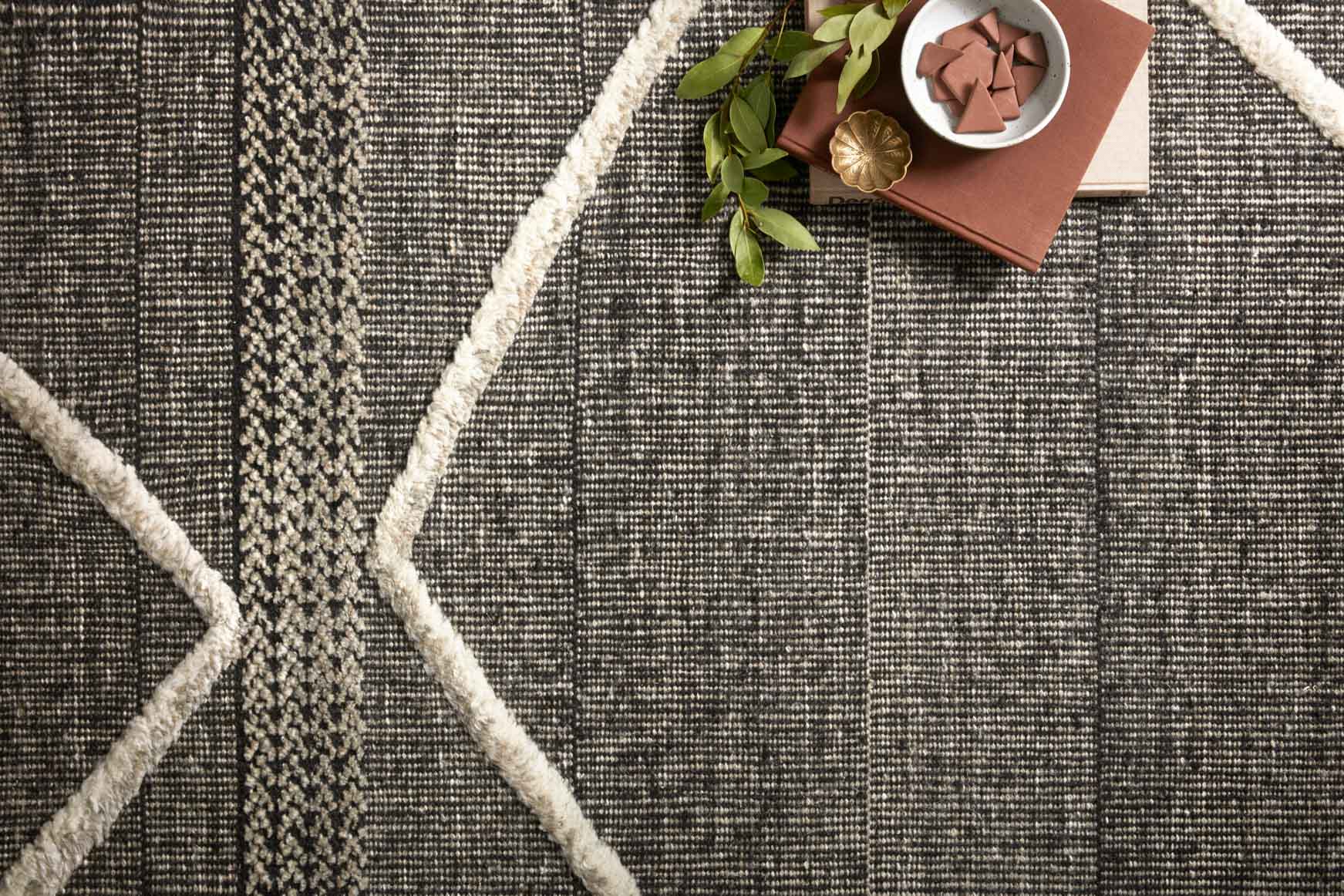 Charcoal rug close-up with beige lattice diamond lines and textured woven surface