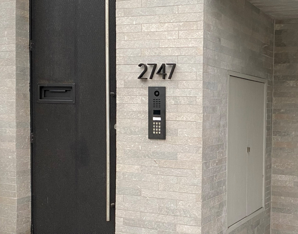 Anthracite grey IP video intercom call panel mounted by entrance number 2747