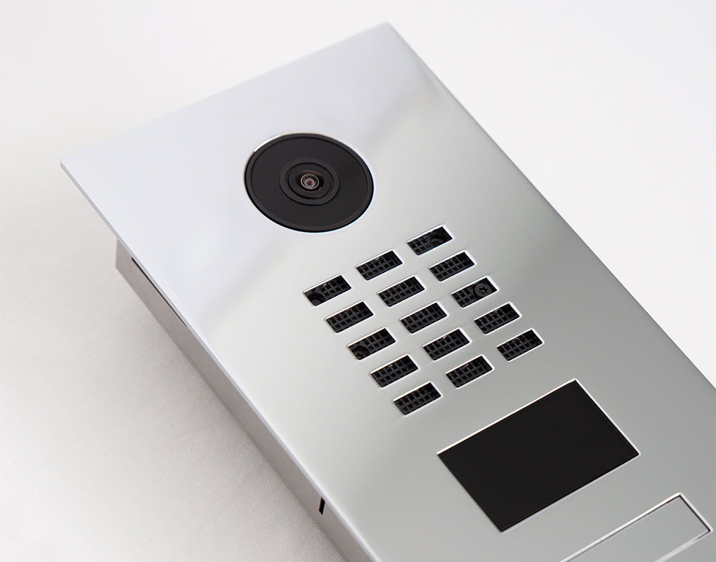 Silver video door station with round camera, button keypad grid, and call panel