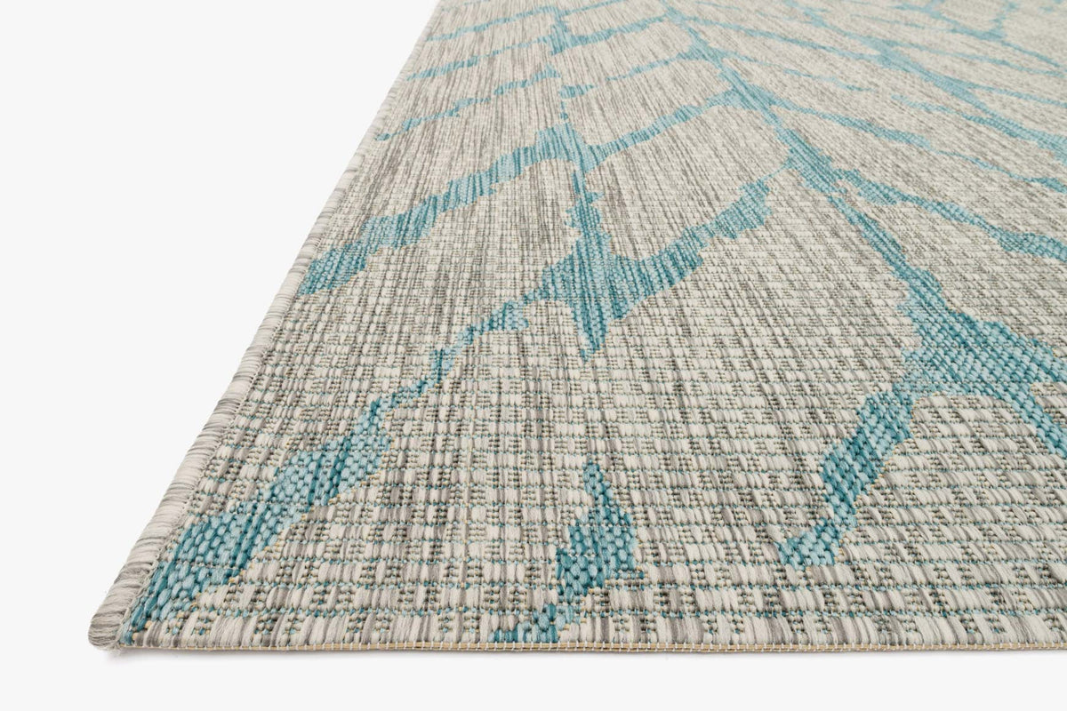 Indoor/outdoor rug corner detail with mist base, aqua chevron stripes, woven texture