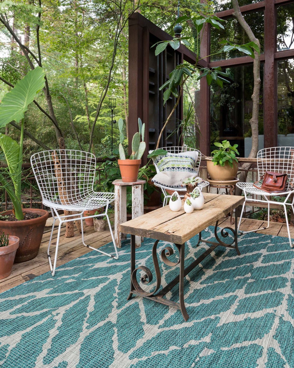 Teal and grey outdoor rug with bold white chevron pattern, full view