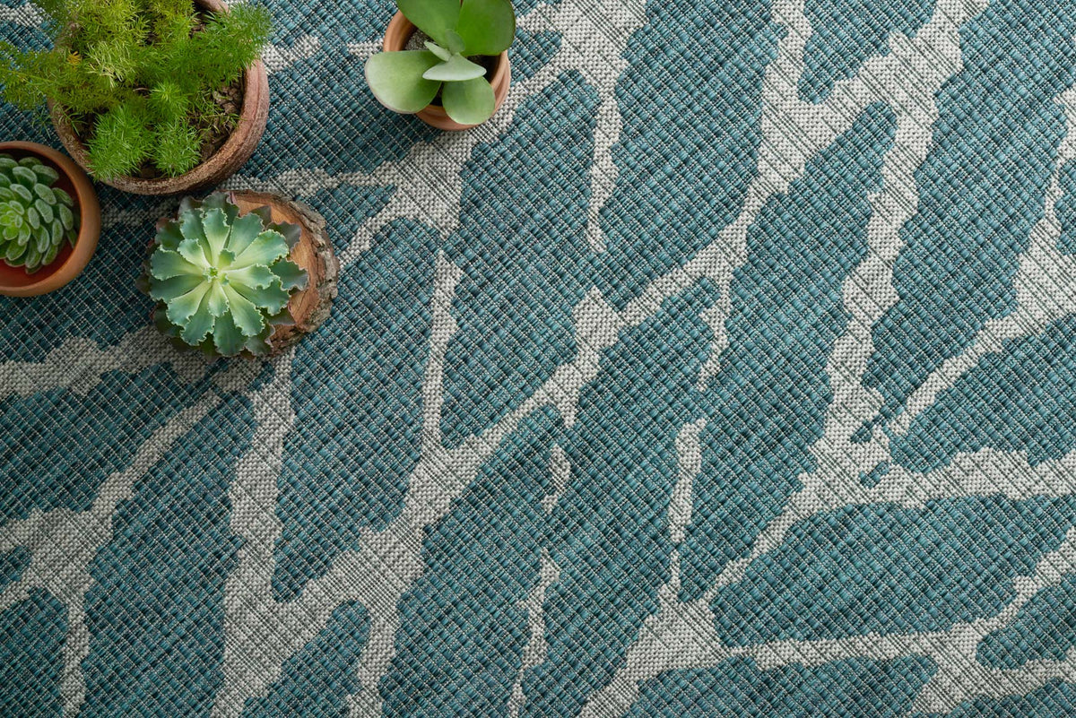 Close-up teal and grey rug with textured white chevron lines