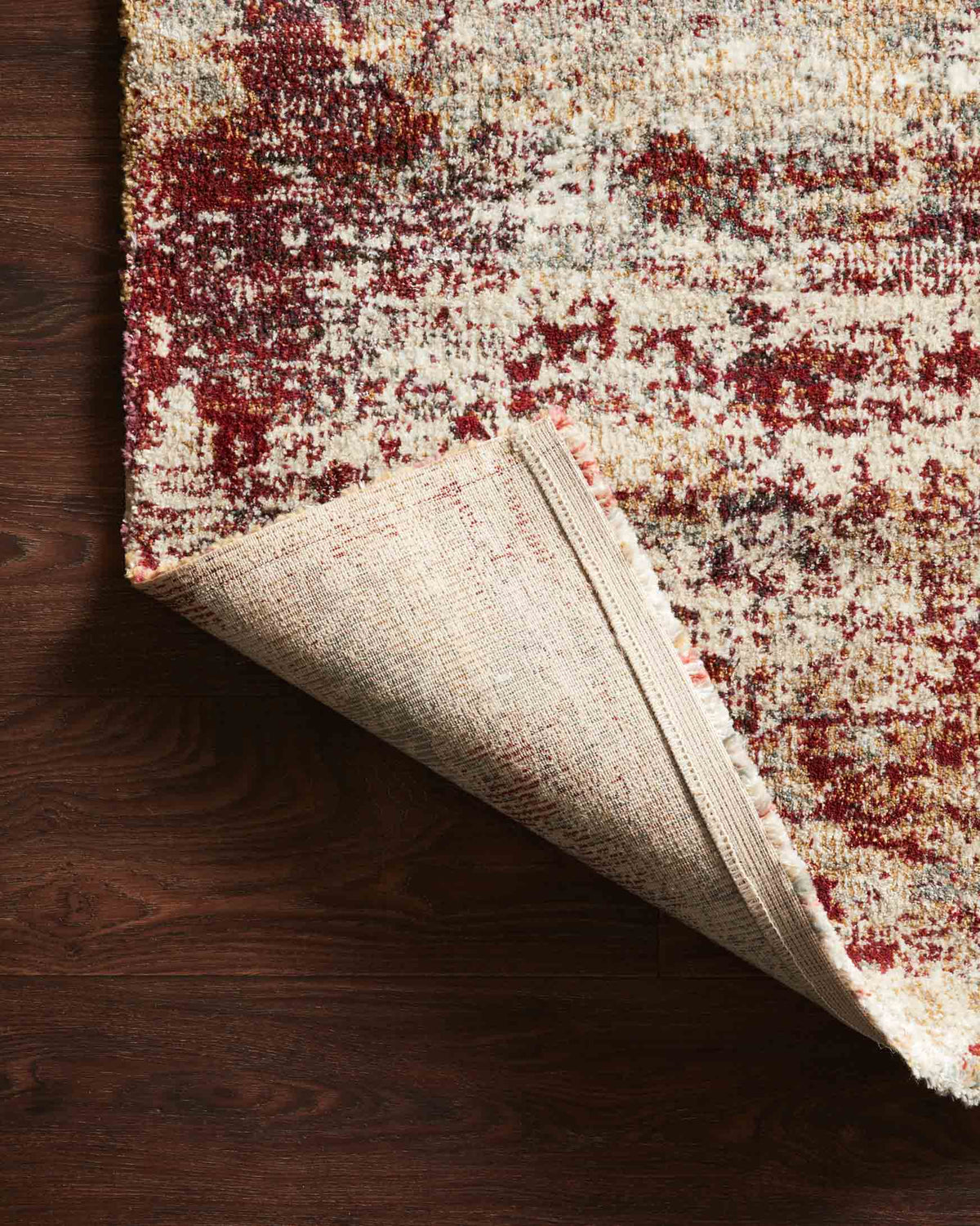 Contemporary power-loomed rug edge view, cream underside with rust abstract pattern
