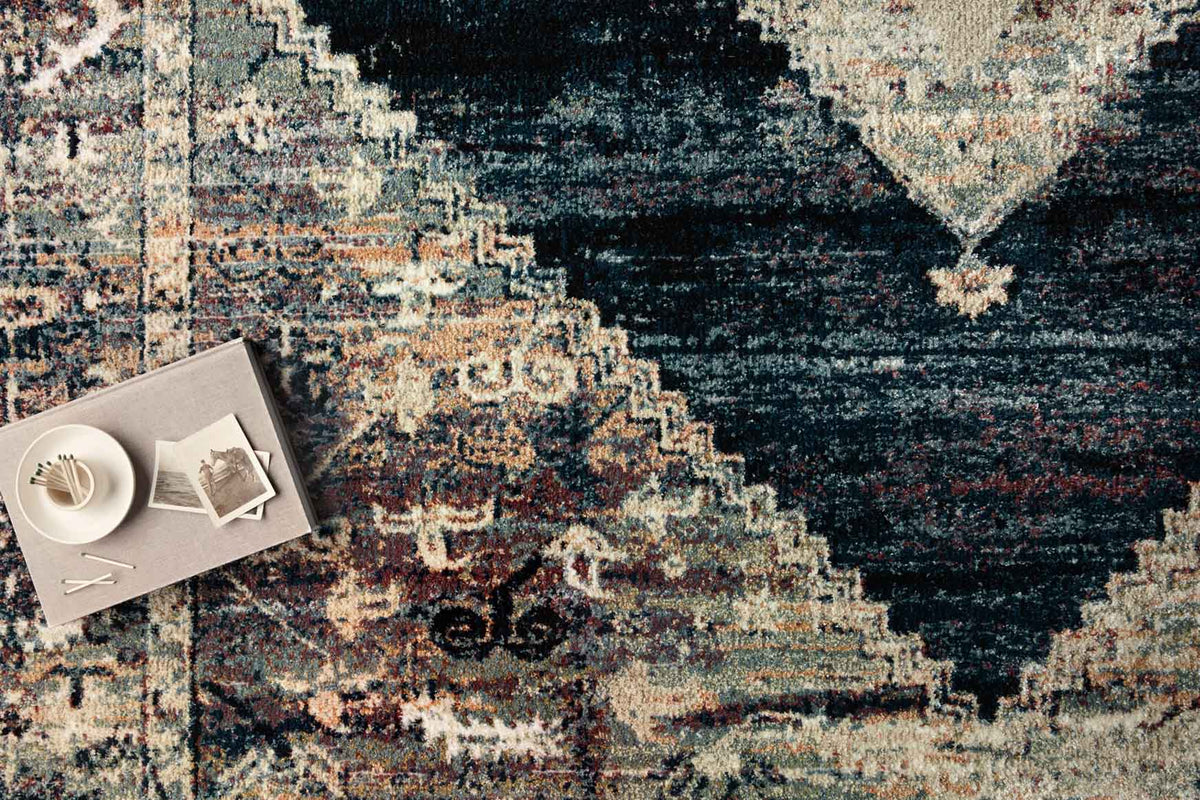 Close-up of power-loomed rug texture with ink-blue and cream distressed tile motif