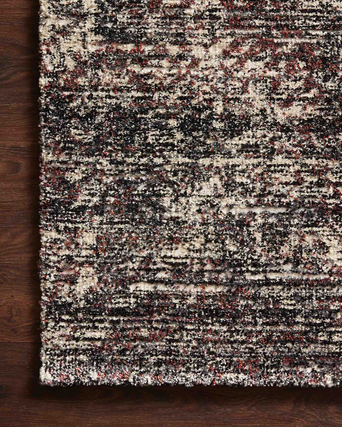 Contemporary speckled power-loomed rug with dark base, cream highlights, and bound edge