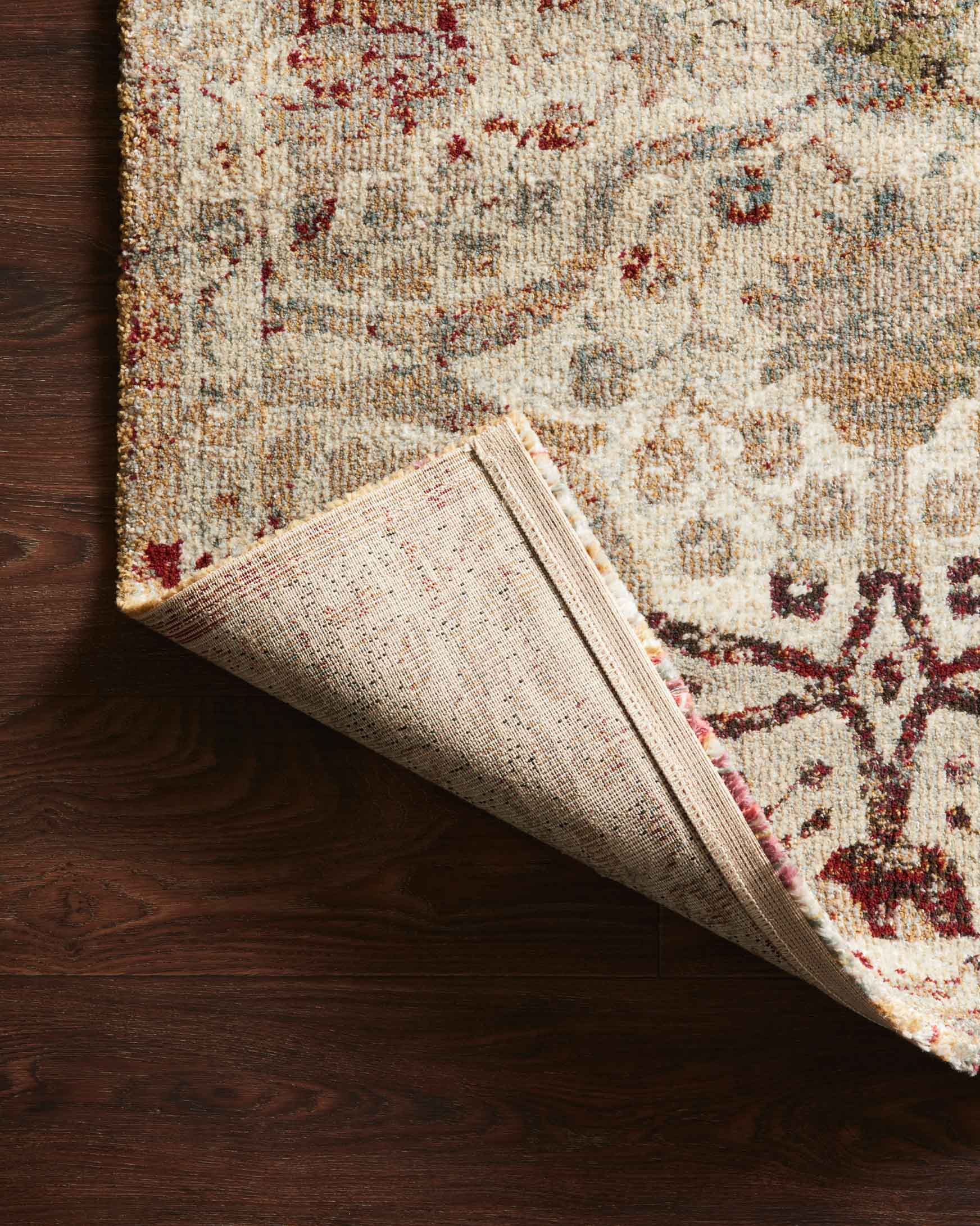 Cream and silver rug with rolled corner, featuring burgundy decorative pattern
