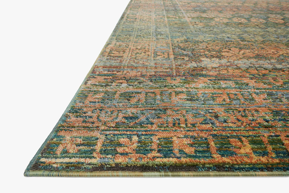 Teal and orange textured rug with dense geometric border, angled view