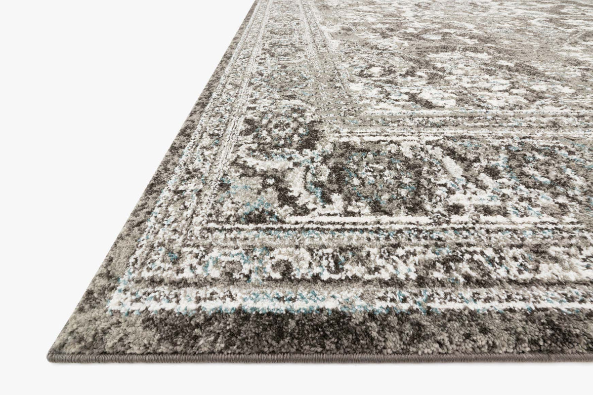 Charcoal and ivory rug corner with decorative border and distressed motifs
