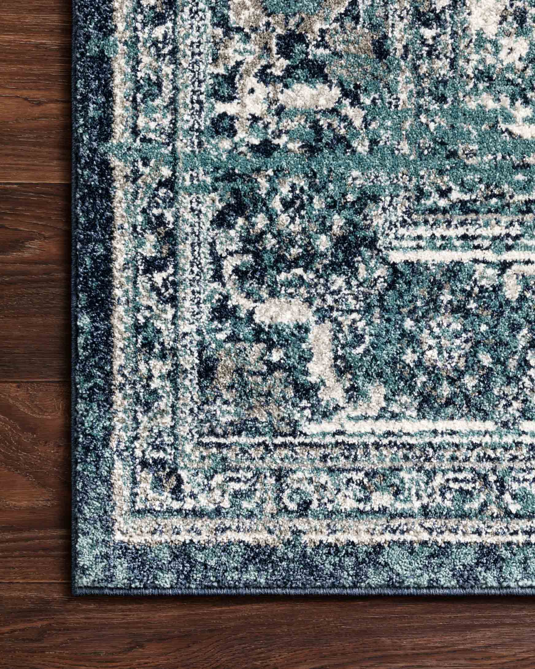 Ocean and ivory rug corner with textured distressed motif and detailed border