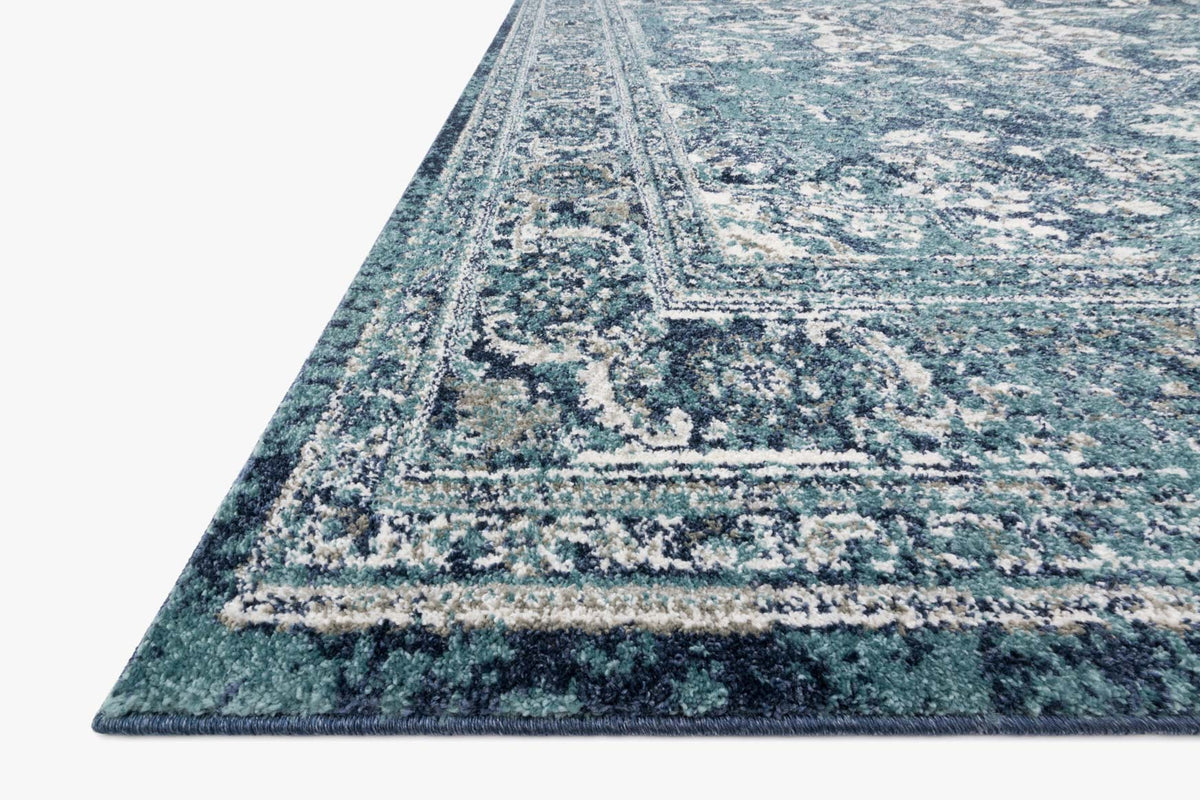 Traditional power-loomed rug corner, ocean blue with ivory distressed motifs