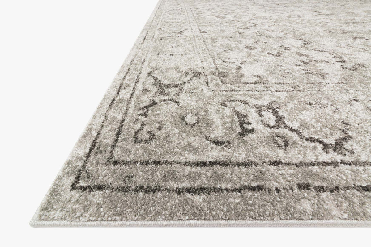 Power-loomed rug corner in silver and grey with ornate distressed border