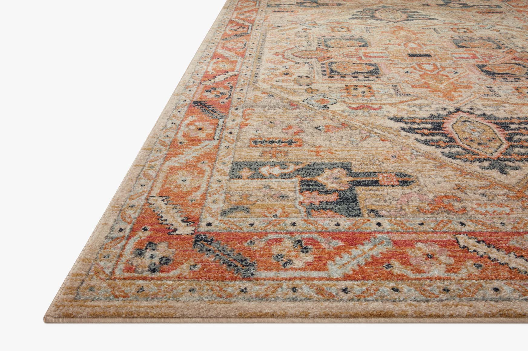 Corner close-up of transitional area rug with distressed geometric pattern in sand and rust