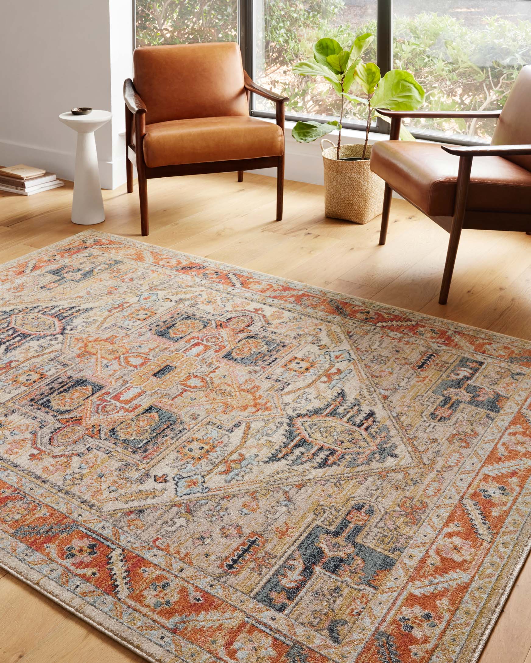 Rectangular transitional area rug featuring distressed motif pattern in sand, orange, and navy blue