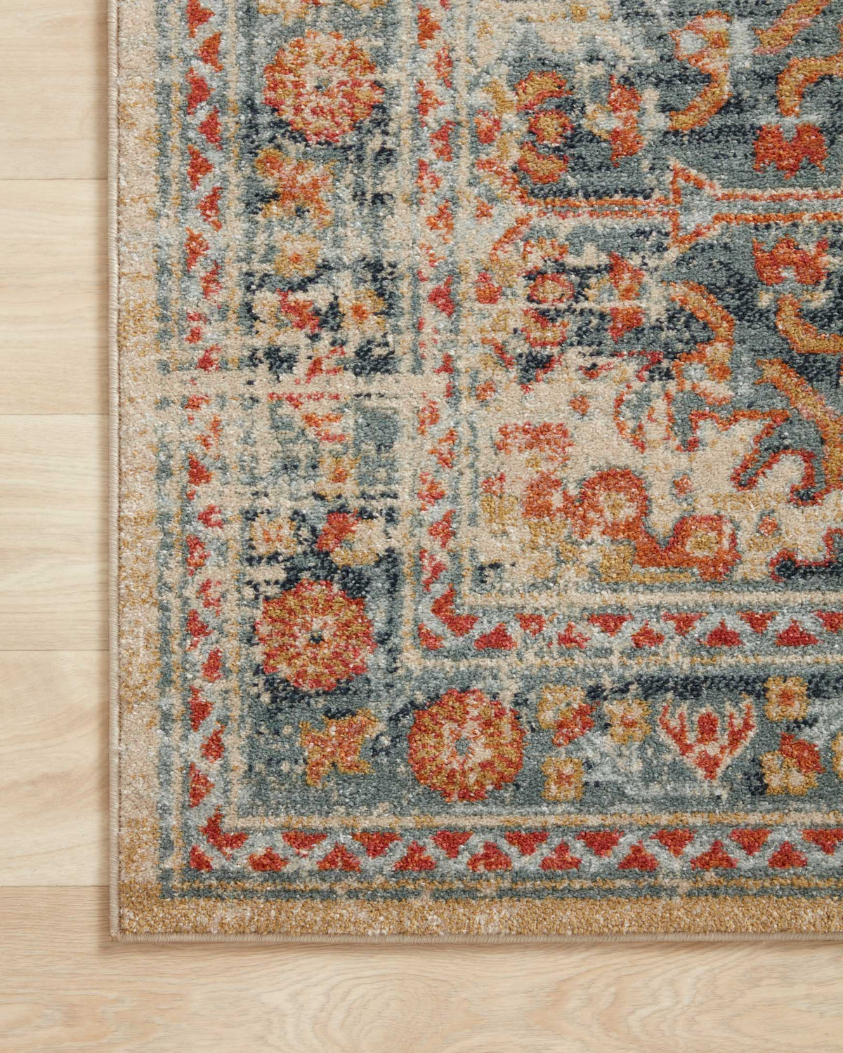Close-up of transitional rug weave with distressed floral details in mist blue and rust
