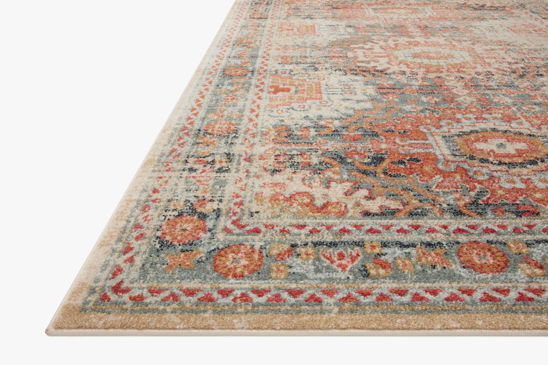 Corner view of transitional power loomed rug in mist blue with orange ornamental borders