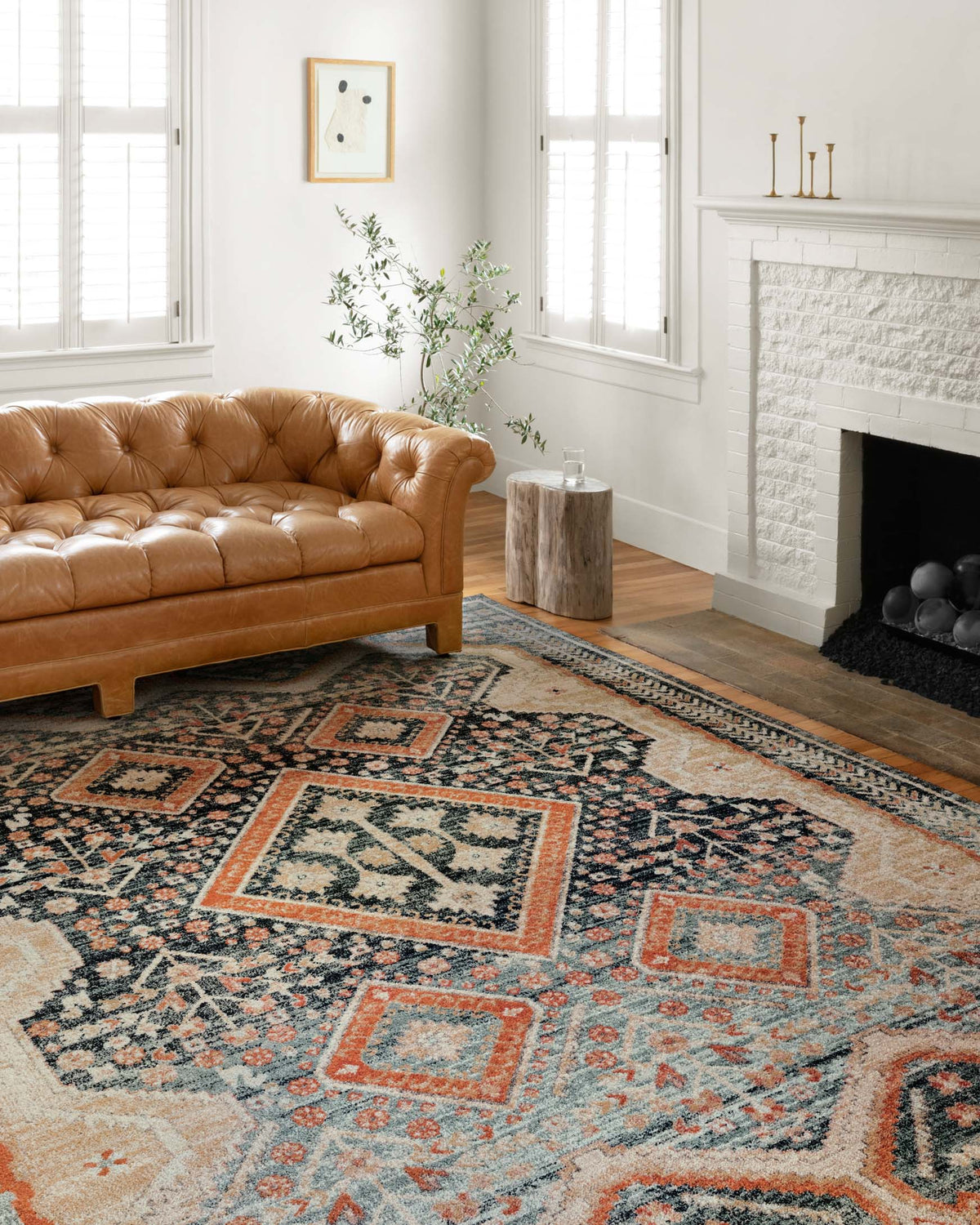 Rectangular area rug with navy and orange geometric medallion pattern and border