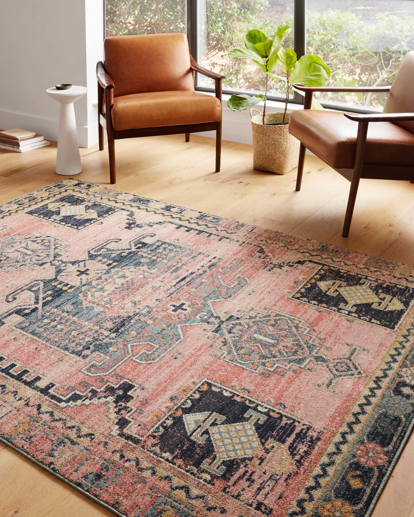 Transitional power-loomed rug in rose pink with navy and tan distressed geometric pattern.