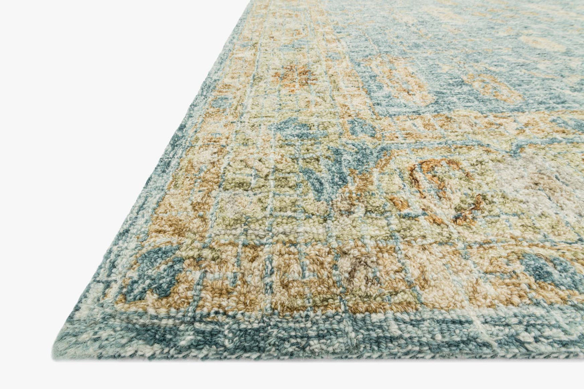 Transitional hooked rug corner, light blue and gold distressed motif, textured loop pile